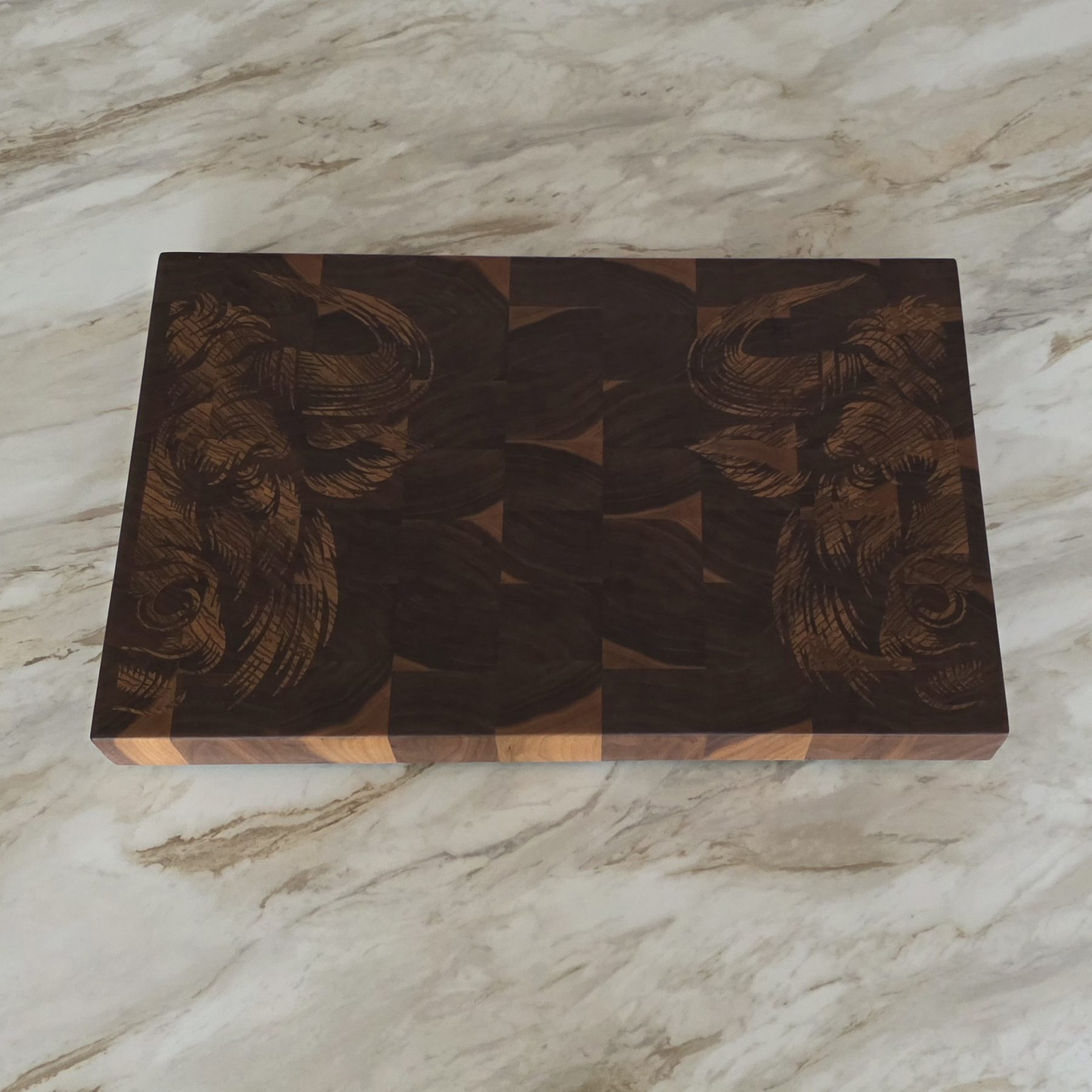 Close-up of engraving cut into a dark walnut end grain cutting board