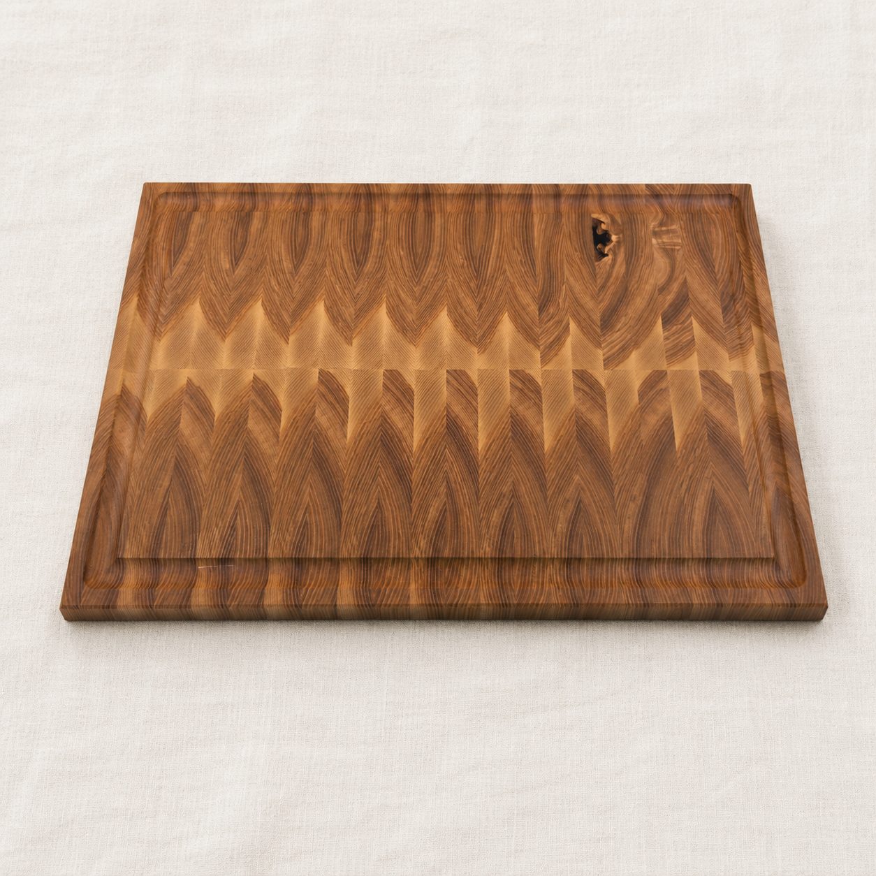 Custom end grain cutting board in figured golden hardwood with a juice groove