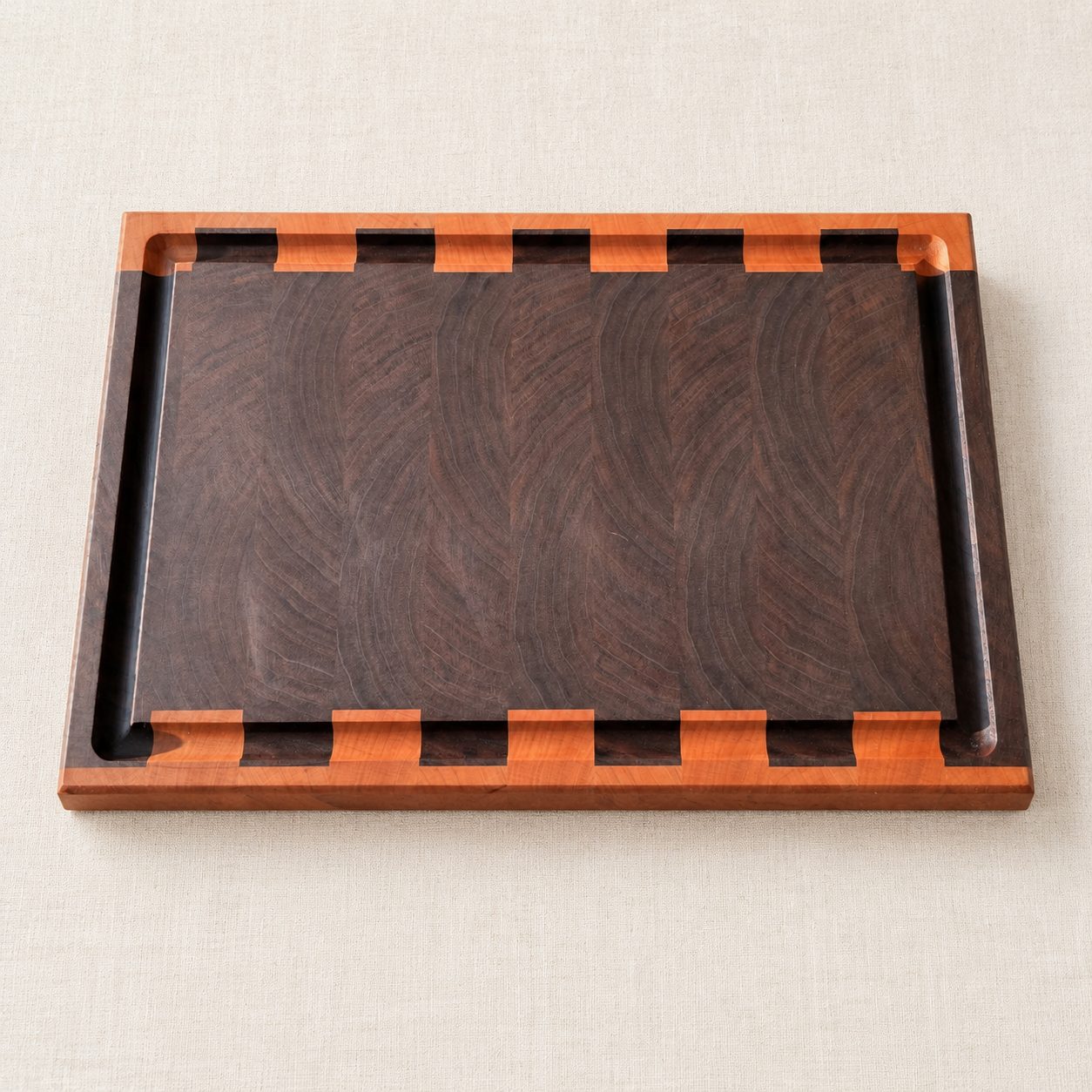 Custom end grain cutting board with a contrasting border, finger notches and a juice groove