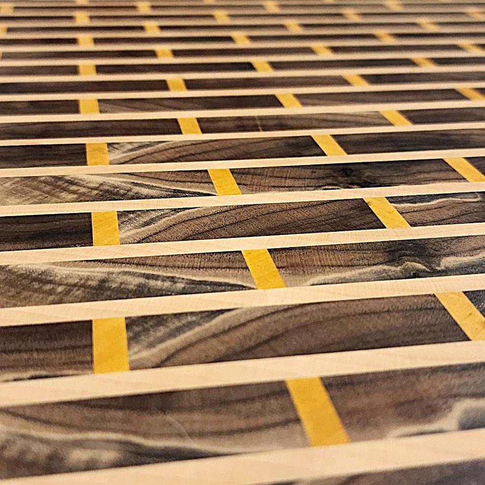 Close-up of pale and yellow accent strips in a custom end grain cutting board